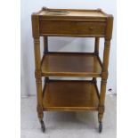 An early/mid 20thC oak three tier hostess trolley, the top accommodating two bottle coasters, raised
