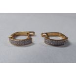 A pair of yellow metal (probably 14k) earrings, set with two rows of diamonds