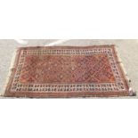 A Persian Baluch rug, decorated with geometric patterns, on a red and blue ground  74" x 39"