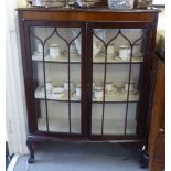 A 1930s mahogany display cabinet with a pair of glazed doors, raised on cabriole legs  51"h  36"w