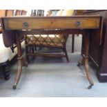 A late Regency mahogany sofa table with a frieze drawer and facsimile on the reverse, raised on