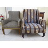 Two dissimilar early/mid 20thC fabric upholstered enclosed armchairs, raised on square, tapered