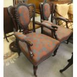 A pair of early 20thC mahogany showwood framed open arm salon chairs, raised on cabriole forelegs