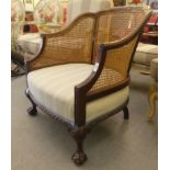 A 1930s mahogany framed bergere tub design chair with caned sides, raised on cabriole legs