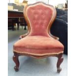 A late Victorian mahogany showwood framed nursing chair, later part button upholstered in red