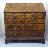 A mid 18thC figured and crossbanded walnut bureau, the fall flap enclosing a fitted interior, over