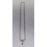 A white gold necklet, set with an emerald and diamonds, on a fine box link chain and a bayonet clasp