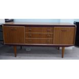 A 1970s/1980s laminated teak effect sideboard with a bank of three central drawers, flanked by two