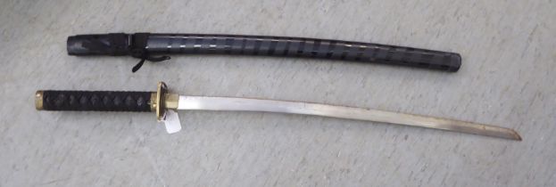 A reproduction of a Japanese Samurai sword with a rope clad handle  the blade 27"L in a scabbard