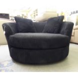 A modern black fabric upholstered 'oversize' swivel armchair