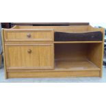 A vintage teak effect veneered telephone table with a cushioned seat, over an open section, a drawer