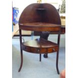 A George III mahogany quadrant washstand with a splashback, over two tiers and a central box drawer,