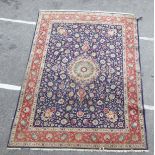 A Persian carpet, decorated with floral and foliate designs, on a mainly dark blue and multi-