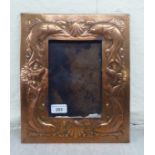 An Arts & Crafts period Newlyn School spot-hammered and pressed copper photograph frame, decorated