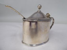 An early 19thC silver oval, bead bordered mustard pot with a hinged, domed lid, thumbpiece, finial