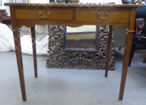 An Edwardian mahogany two drawer writing table, the top set with a black scriber, raised on square