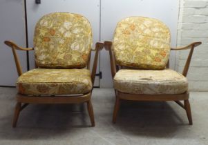 A pair of Ercol blonde elm and beech framed high hoop and spindled back chairs with open arms and