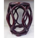 A 20thC Oriental mahogany framed open barrel design stool with simulated bamboo supports