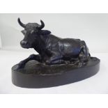 A cast and patinated bronze model, a recumbent cow, on an oval base  bears an indistinctly impressed