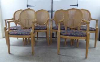 A set of six modern natural oak effect framed dining chairs with a caned panel back, over a fabric