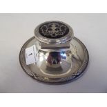 An Edwardian loaded silver capstan design inkwell with cast ribbon tied ornament and a
