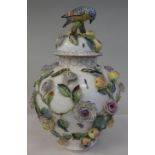 A late 19thC German porcelain baluster shaped vase and cover, surmounted by a hedgerow bird,