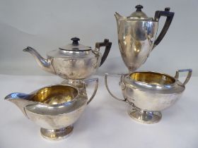 An Edwardian four piece silver tea set of pedestal lamp design, comprising a teapot with a swept