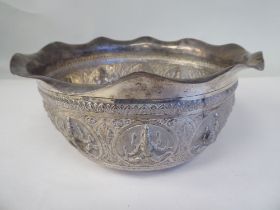 An Asian silver coloured metal bowl with a cut, flared, wavy edged, everted rim, cast and chased