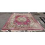 A Chinese washed woollen carpet, decorated with flora in pastel colour, on a pink ground  110" x