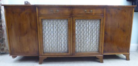A modern Regency style yewwood finished, breakfront sideboard with ebony string inlaid decoration,