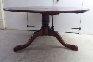 A modern oak pedestal table, the tip-top raised on a cabriole tripod base  30"h  58"w