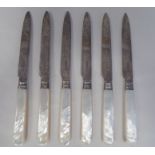 A set of six Edwardian foliate engraved scrolled silver tea knives, on abalone handles