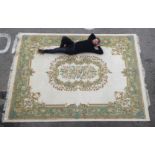 An Indian Kayan wash woollen carpet with a central motif bordered by additional floral and C-