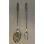 A Liberty & Co silver coloured metal olive spoon and fork, on decoratively cast handles
