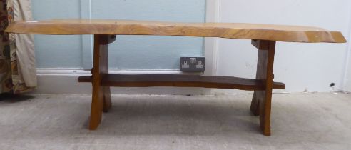 A modern rough sawn planked centre table, raised on a pegged base  18"h  51"w