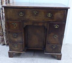 A Georgian mahogany crossbanded and feather inlaid kneehole desk, the top with re-entrant corners,