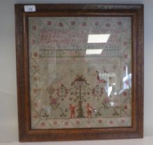 A 19thC sampler worked in coloured wool, incorporating the alphabet and Arabic numerals, figures,