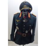 A German World War II design military tunic with emblems and a peaked cap (Please Note: this lot