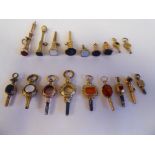 Eighteen antique and variously decorated 9ct and 15ct gold and yellow metal watch keys, pendant