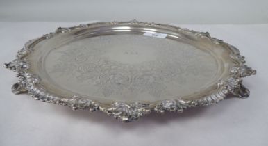 A late Victorian silver salver with a raised, C-scrolled and shell cast border and conforming