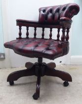 A modern Captains style mahogany showwood framed desk chair, stud and part button upholstered in