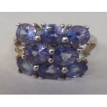 A silver ring, set with eight tanzanite stones