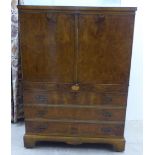 A modern walnut finished hi-fi cabinet, enclosed by a pair of doors, over a fall front, featuring