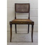 A Regency gilded black lacquered and overpainted hall chair with a caned back panel and seat, raised