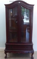 A modern mahogany display cabinet with two glazed doors and a drawer, raised on cabriole legs  75"h