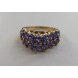 A 9ct gold half-eternity ring, set with a tiered tanzanite cluster  boxed