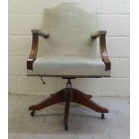 A 20thC mahogany showwood framed desk chair with open arms, stud upholstered in olive coloured hide,