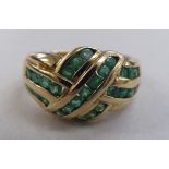 A 9ct gold crossover ring, set with bands of emeralds  boxed