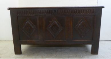 An early 18thC panelled oak coffer with straight sides and a hinged lid, raised on block feet  27"h