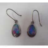 A pair of silver earrings, each set with a pear shaped opalescent gemstone